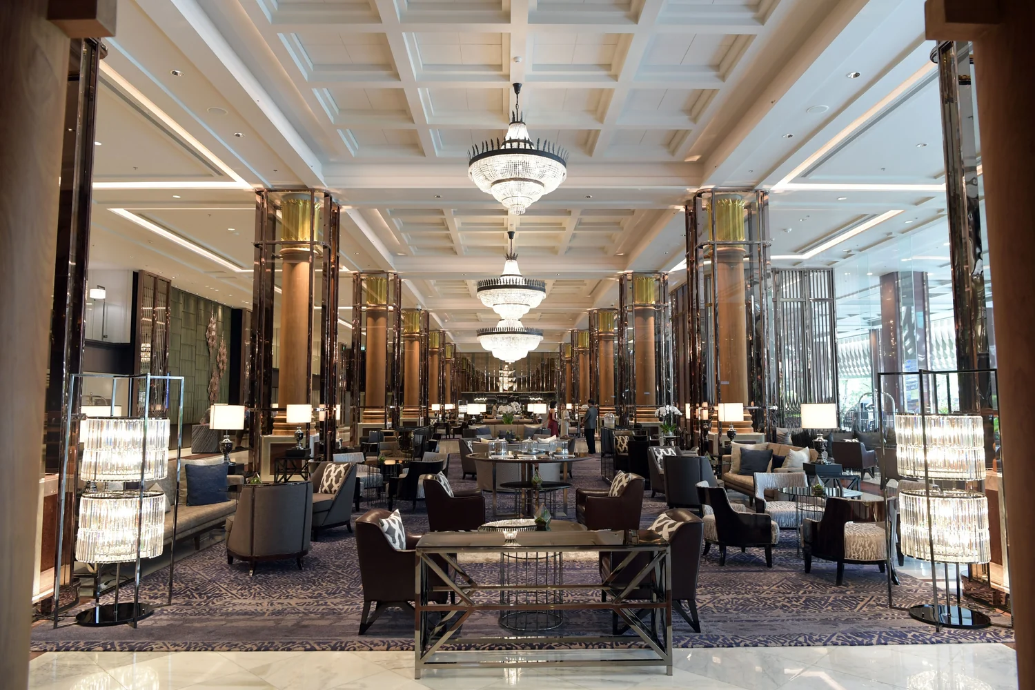 Spacious hotel lobby with grand chandeliers and luxurious seating