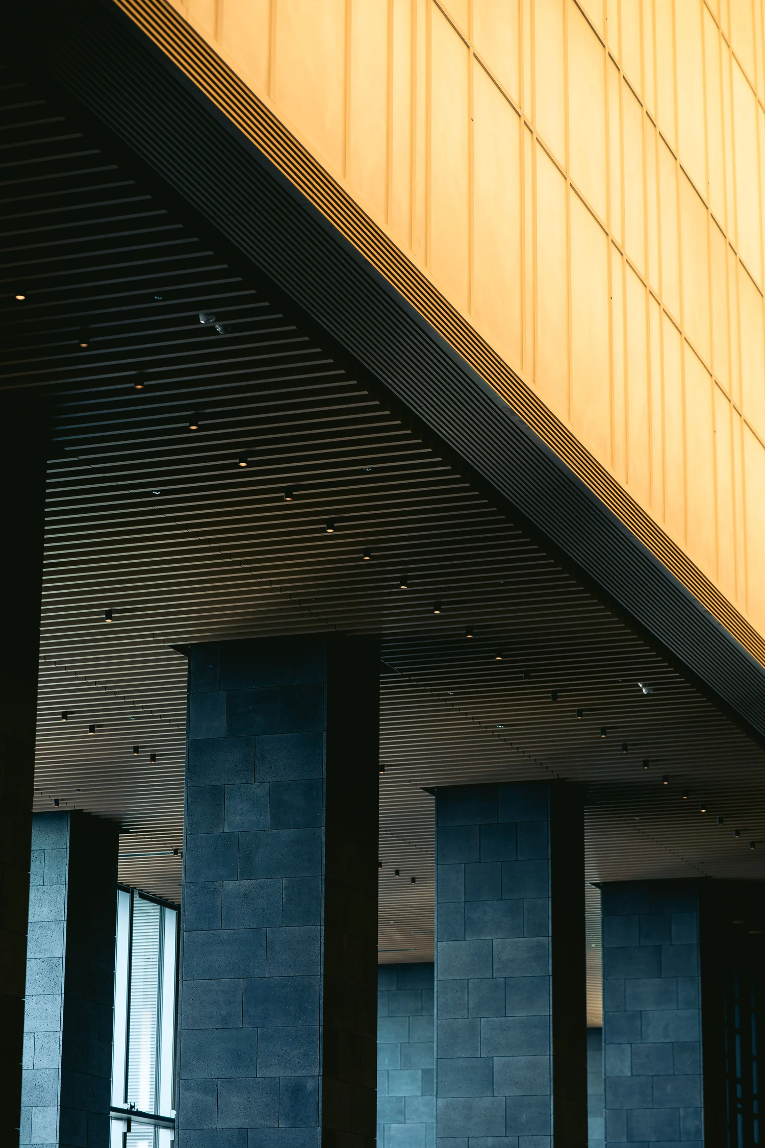 Minimalist hotel lobby with sleek columns and warm lighting design